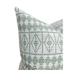 a green and white pillow on a white background