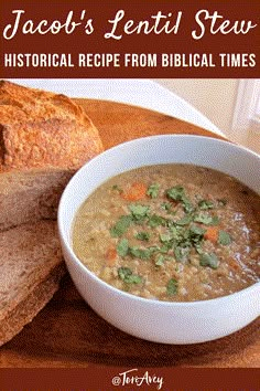 a white bowl filled with soup next to sliced bread