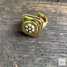 This Bold And Chunky Brass Flower Ring Features Rounded Square Edges Framing A Patterned Flower Center. Brass Adjustable Sizing. Ring Design Measures 1.25-Inches In Height By .75-Inch In Diameter. Fair Trade Made In India: Re-Imagining The Aesthetics Of Sustainable, Ethical Fashion, This Ring Is Handmade By Artisans In Village Communities In India, Often Times Using Eco-Friendly Materials. We Are Pleased To Work With Asha Through Our Partnership With Global Crafts. Our Ring Will Come In A Linen Adjustable Vintage Gold Flower Ring, Vintage Adjustable Gold Flower Ring, Adjustable Gold Brass Flower Ring, Adjustable Gold Flower Ring In Brass, Adjustable Metal Flower Ring With Open Design, Adjustable Flower Shaped Metal Ring, Adjustable Metal Flower Ring, Adjustable Brass Flower Ring, Adjustable Brass Flower Ring As Gift