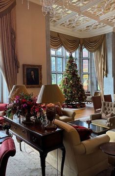 a living room filled with furniture and a christmas tree in the middle of the room