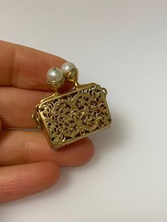 Vintage 14k yellow gold clutch purse with filigree design and pearl clasp charm. The purse opens up. The charm is 7.67 grams of gold. Evening Yellow Gold Jewelry With Box Clasp, Yellow Gold Jewelry With Gold Clasp For Evening, Evening Yellow Gold Jewelry With Gold Clasp, Elegant Gold-tone Jewelry With Box Clasp, Elegant Evening Jewelry With Gold Clasp, Gold Rectangular Filigree Jewelry, Compact Yellow Gold Jewelry For Formal Occasions, 14k Gold Rectangular Jewelry For Evening, Ornate Gold Rectangular Jewelry