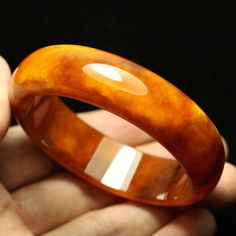 59mm Golden Yellow and White Clouds Hand-carved Natural Jade Bangle #A3 weight: 76.5g, 421.5 Ct Jade NameNatural Jade Item SizeInner diameter: 58 mm Width:17.6mm Thickness: 7.1 mm This unique bangle has lots of internal feature with clouds, silk streaks and wen. Inviting autumn color with this golden orange tawny with white flowers. This is a gorgeous and high quality jadeite bangle. Luxury Collectible Round Bangle, Luxury Carved Bracelet Jewelry, Handmade Luxury Bangle For Formal Occasions, Luxury Handmade Bangle For Formal Occasions, Elegant Carved Orange Jewelry, Luxury Carved Bangle Jewelry, Elegant Orange Carved Jewelry, Luxury Carved Bracelets For Formal Occasions, Carved Brown Bangle Jewelry