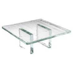 a square glass table with metal legs and two sections in the middle, on a white background