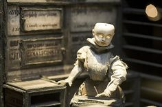 a toy robot sitting on top of a wooden table next to a box filled with money