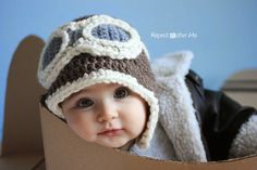 a baby wearing a hat in a cardboard box