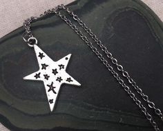 Love this fun and whimsical silver star necklace! Made from allergy free, plated silver.  It hangs from a silver plated simple 18" chain necklace with a lobster clasp. The star measure 1" long by 3/4" across. I have matching earrings in my shop, if you would like the whole set.https://www.etsy.com/listing/210027881/silver-star-earrings-celestial-earrings?ref=shop_home_active_21This is perfect for everyday, year round wear and would also make a wonderful gift.Thanks for stopping by and please tak Silver Star Print Necklace, Silver Star Print Necklace For Gift, Silver Star Print Necklace Perfect For Gift, Silver Necklace With Star Print For Gift, Silver Star Print Jewelry As Gift, Silver Star Print Jewelry For Gift, Silver Jewelry With Star Print As Gift, Silver Jewelry With Star Print For Gift, Silver Star Charm Necklace