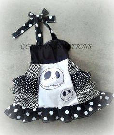 a black and white polka dot dress with a skull on the front, bow at the back