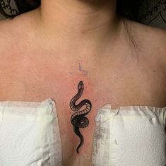 a woman's chest with a tattoo on it that has a snake on it