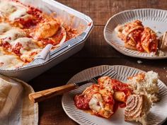 two plates filled with lasagna casserole on top of a wooden table