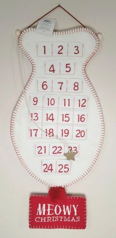 a red and white clock hanging from the side of a wall