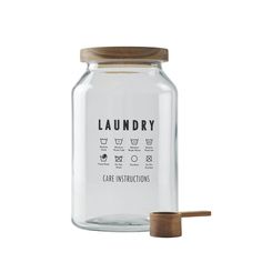 a glass jar with a wooden lid that says laundry care instructions on the front and side