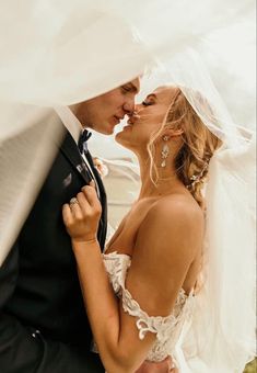 a bride and groom kissing under the veil