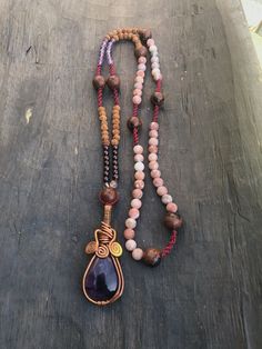 I created this collection of necklaces that I called Malasana, in honor to the Art of Yoga. Each piece of jewelry has a main semiprecious stone beautifully worked with copper. The stones are high quality and they come from South America. They are accompanied by 108 pearls and sometimes by micro macramé knots. Here you have a necklace in violet/purple tones with Amethyst, Mahogany Obsidian, Citrine, Garnet, Rudraksha and Jasper.  The pendant is a good looking Amethyst, one of the main stones of the new Aquarius Age. It is an extremely powerful and protective stone with a spiritual vibration.  I wrote a lot about stones on my other listings. I strongly encourage you to read about stones and crystals and feel which quality works best for you. Crystals are our friends. The length mentioned is Adjustable Copper Jewelry With Gemstone Beads, Spiritual Copper Jewelry With Natural Stones, Adjustable Bohemian Copper Necklace, Wire Wrapped Long Necklace In Spiritual Style, Beaded Copper Pendant Jewelry, Artisan Amethyst Gemstone Beads Jewelry, Copper Beaded Pendant Jewelry, Agate Pendant For Meditation, Handmade Amber Crystal Necklace For Meditation