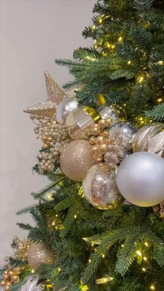 a decorated christmas tree with gold and silver ornaments