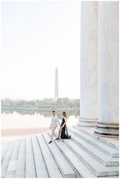 a man and woman standing on steps next to the washington monument