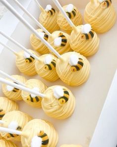 honeybee cupcakes with white and yellow frosting are arranged in a row