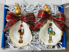 two christmas ornaments in a box with ribbon