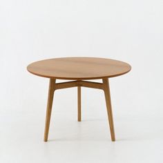 a small round table with wooden legs on a white background