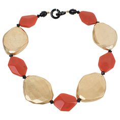 This refined Angela Caputi choker necklace, made in Italy, features gilded metallic coating resin elements contrasted with burnt orange flat beads. Each organic pebble bead is carved, dimensional, and geometric. Her color matching is always extremely classy, perfect for casual and fancy occasions. As you know, Caputi jewelry is not signed. This pre-owned necklace has no original label, but this piece has the brand's signature two-ring closing clasp. Angela Caputi has produced resin and Lucite je Resin Choker, Choker Necklace Gold, Gold And Orange, Flat Beads, Lucite Jewelry, Gold Choker Necklace, Color Naranja, White Gold Necklaces, Accessories Jewelry Necklace