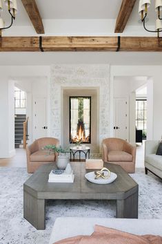 a living room with two couches and a fire place in the fireplace, surrounded by white walls