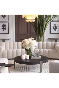 a living room filled with furniture and flowers on top of a coffee table in front of a couch