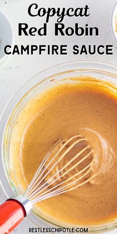 a bowl filled with sauce and whisk on top of a counter next to other ingredients