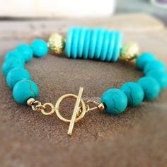 This turquoise bracelet created by Jewelry By Carmal is made of: turquoise (howlite) gemstones, vermeil: beads, gold filled: beads, toggle and findings. This bracelet measures 7 1/2 inches in length. View more beaded bracelets: http://www.etsy.com/shop/jewelrybycarmal?section_id=8002918 WE OFFER FREE STANDARD SHIPPING WITHIN THE UNITED STATES. Our jewelry is unique and custom designed and most of our jewelry can easily be resized at no additional charge. We would love to assist you with your cus Handmade Turquoise Amazonite Bracelets, Turquoise Howlite Jewelry For Jewelry Making, Elegant Turquoise Beaded Bracelets With Natural Stones, Amazonite Bracelet Jewelry In Gold, Elegant Turquoise Jewelry With Spacer Beads, Gold Amazonite Bracelet Jewelry, Gold Amazonite Bracelet, Turquoise Howlite Beaded Bracelets As A Gift, Turquoise Amazonite Beaded Bracelets With Gemstone Beads