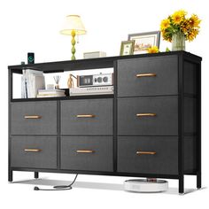 an entertainment center with many drawers and electronics on it's sides, along with a white floor lamp