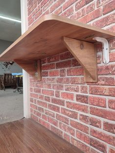 a wooden shelf sitting on the side of a brick wall