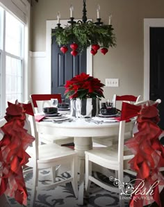 a dining room table decorated for christmas with poinsettis