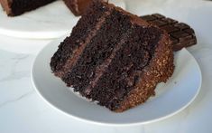 there is a piece of chocolate cake on the plate and one slice has been cut