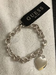 GUESS - NEW SILVER TONE CHAIN LINK HEART PENDANT WOMENS 7" BRACELET | eBay Trendy Metal Heart Bracelet For Valentine's Day, Trendy Silver Heart Bracelet For Gift, Silver Chain Link Bracelets With Charms, Trendy Metal Bracelets With Heart Charm, Trendy Silver Chain Heart Jewelry, Silver Heart-shaped Chain Bracelet, Adjustable Silver Metal Heart Bracelet, Valentine's Day Metal Chain Jewelry, Silver Charm Bracelet With Adjustable Chain For Valentine's Day