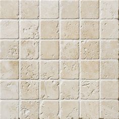 a close up view of a white brick wall with small square tiles on the side