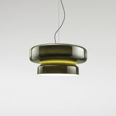 a light that is hanging from a wire in the air with a white wall behind it