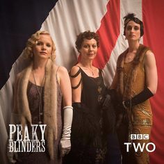 three women standing next to each other in front of an american flag with the words peaky blinders on it