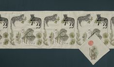 a table runner with animals and plants on it