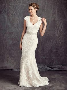 a woman in a wedding dress posing for the camera with her hand on her hip