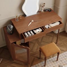 a wooden desk with drawers and a mirror on it's side, in front of a window