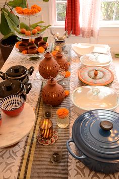 the table is set with dishes, plates and vases on it's side