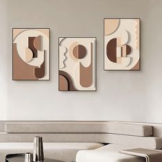 three abstract paintings hang on the wall above a coffee table in a modern living room