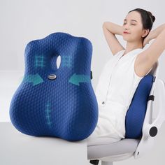 a woman sitting in an office chair with her arm resting on the back of a pillow