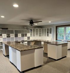 a large kitchen with lots of cabinets and counter tops in the middle of an open floor plan