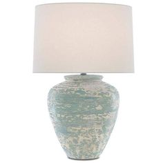 a blue and white vase with a light on it's side next to a lamp