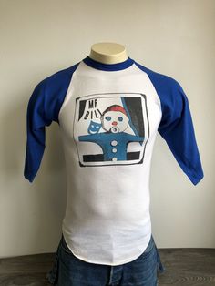 Mr. Bill 70s Jersey Shirt A very unique rare Mr. Bill shirt. A great piece from the 70s. Take Mr. Bill on all your adventures with this shirt. Condition: Excellent preowned condition. Just a few light marks and and some piling. Overall Great shirt! See a smashing selection of vintage tees in my shop https://www.etsy.com/shop/sweetVTGtshirt?section_id=11916470&ref=shopsection_leftnav_3 Measurements (Inches): Pit to Pit: 15 1/2 Waist: 15 1/2 Sleeves from shoulders: 19 Total length: 27 Size: Ta Unisex Screen Print Shirt For Fan Merchandise, Unisex Fan Merchandise Shirt With Screen Print, Retro Cotton T-shirt With Screen Print, 90s Style Cotton Screen Print Shirt, Vintage Cotton Shirt For Fan Merchandise, Retro Fitted Shirt With Screen Print, Retro Fitted Pre-shrunk Top, Fitted Retro Cotton T-shirt, Retro Fitted Top