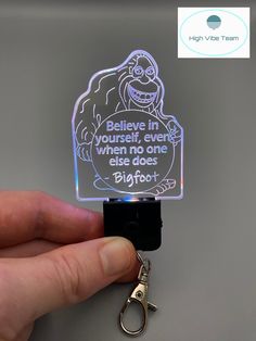 someone is holding a keychain that has a light up sign on it with the words believe in yourself, even when no one else does