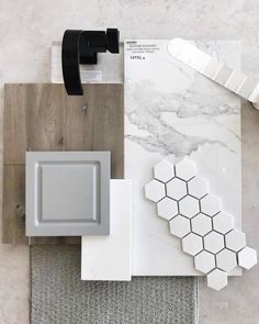 some white and grey tiles are laying on the floor