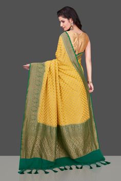 Lovely yellow georgette Banarasi saree for special occasions. The saree has an antique zari green border and pallu and is adorned with overall small zari buta. It comes with a blouse piece. Shop online from Pure Elegance. Disclaimer: The shown stitched blouse on the model is for display purpose only. The saree comes with a matching blouse piece and finished with fall and piko. The actual product may vary slightly from the image. These are custom orders, hence expect slight variation in color, placement of the motif or buta. ESTIMATED DELIVERYBecause this is a custom order, it would take about 4 weeks from the date of purchase. RETURN POLICYThis product is a custom order and cannot be returned or exchanged. Georgette Banarasi Saree, Muga Silk, Banarasi Sari, Green Border, Fashion Journals, Indian Sari, Banarasi Saree, Traditional Fabric, Banarasi Sarees