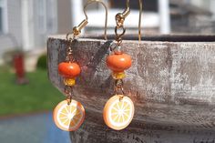 Price is for 1 pair of food earrings.   Please select which dangle earring set you want. Now available in:     - Dragonfruit     - Oranges A touch of sweet, a touch of charm! These cute food earrings add summer color and summer fun to any outfit. These dangle earrings boast bright colors and a fresh feel for spring, summer and more! Clay polymer charms, gold colored nickel free ear wires and glass beads. Clay polymer earrings. Please select which set of earrings you want.  Great gift under 10! I loved the playful fruit charms in bright colors! Wonderful for adding color to your outfits, or a great gift for any foodie! A gift for her, gift for teen, gift for girl, gift for sister, gift for mom, gift for friend, thank you gift, gift for teacher, gift for summer, tropical earrings, food earri Cute Fruit Design Drop Earrings, Orange Earrings For Summer Gifting, Fun Orange Dangle Earrings, Summer Orange Jewelry With Fruit Design, Cute Orange Handmade Jewelry, Cute Orange Dangle Jewelry, Cute Handmade Orange Jewelry, Unique Orange Round Earrings, Cute Dangle Earrings With Fruit Design