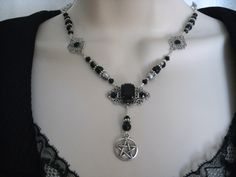 "This beautiful necklace has black Czech glass beads, pewter silver accent beads, silver plated filigree accents, black rhinestones, silver plated filigree pendant with black faceted glass setting and a pewter silver pentacle. 18\" long. Toggle clasp." Gothic Silver Jewelry With Black Beads, Gothic Black Beads Jewelry For Halloween, Gothic Black Beads Halloween Jewelry, Gothic Dangle Necklaces For Jewelry Making, Gothic Silver Beaded Necklaces With Black Beads, Gothic Metal Jewelry With Black Beads, Gothic Silver Necklace With Black Beads, Silver Gothic Necklace With Black Beads, Gothic Black Beaded Metal Jewelry