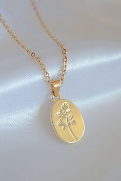 "Elegant and classy floral necklace with coin pendant with flower engraving. This floral necklace is made of 24 karat gold plated stainless steel. This necklace is very versatile and you can combine it perfectly with minimalist, feminine, elegant, classic and casual outfits. It can be used daily as it is waterproof, tarnish resistant and hypoallergenic (suitable for sensitive skin). DETAILS ✨ Material: 24 karats gold plated over stainless steel. ✨ Chain Length: 39 cm + 5.5 cm / 14.9 inch + 2.1 i Gold Necklace With Flower Charm On Oval Pendant, Gold Oval Pendant Necklace With Flower Charm, Gold Necklace With Oval Pendant And Flower Charm, Rose Gold Tarnish Resistant Oval Pendant Necklace, Rose Gold Oval Jewelry With Flower Charm, Oval Rose Gold Jewelry With Flower Charm, Gold Oval Pendant Necklace With Birth Flower, Gold Necklace With Oval Pendant And Birth Flower, Rose Gold Oval Gold-plated Necklace